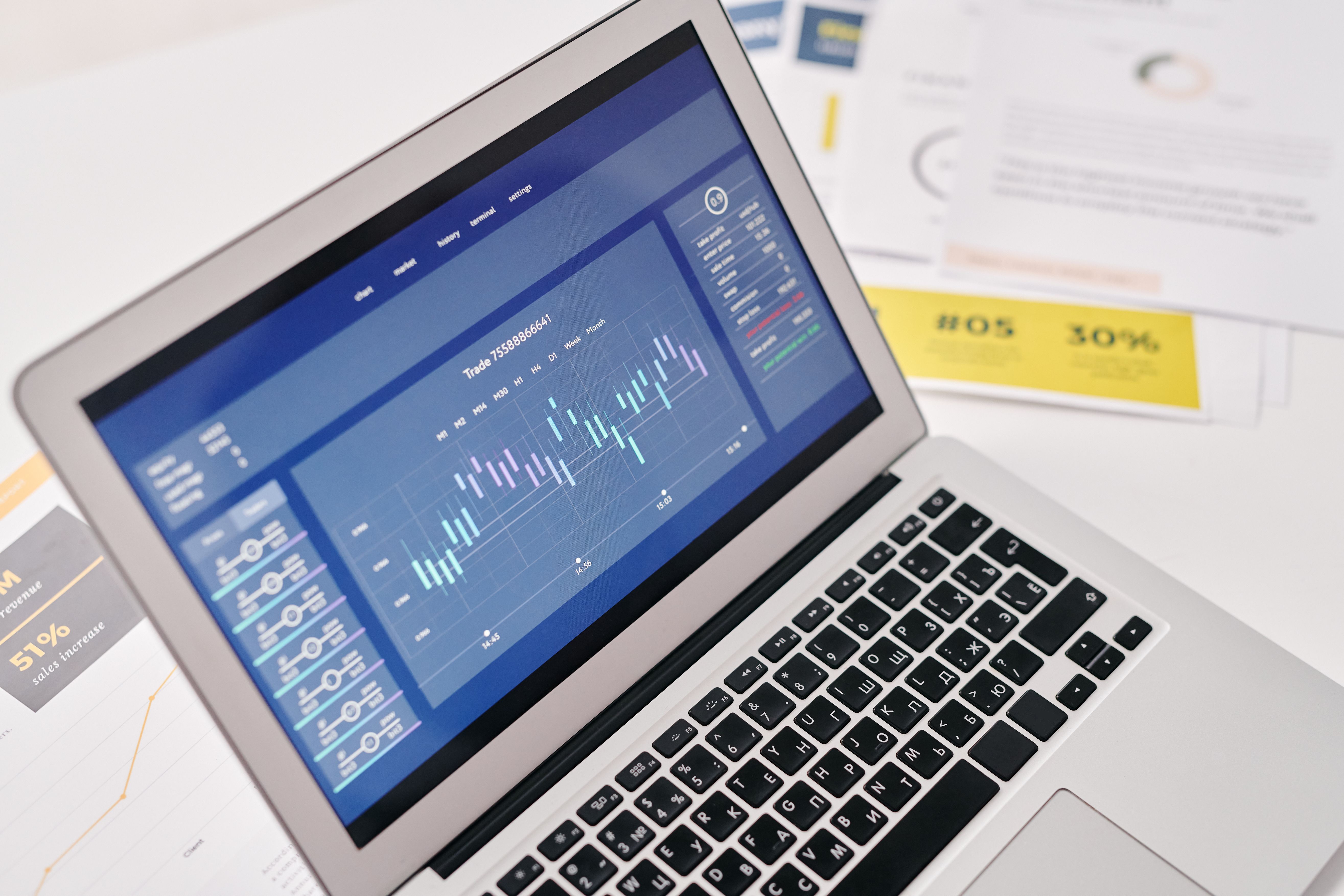 Open laptop showing analytics dashboard beside business documents