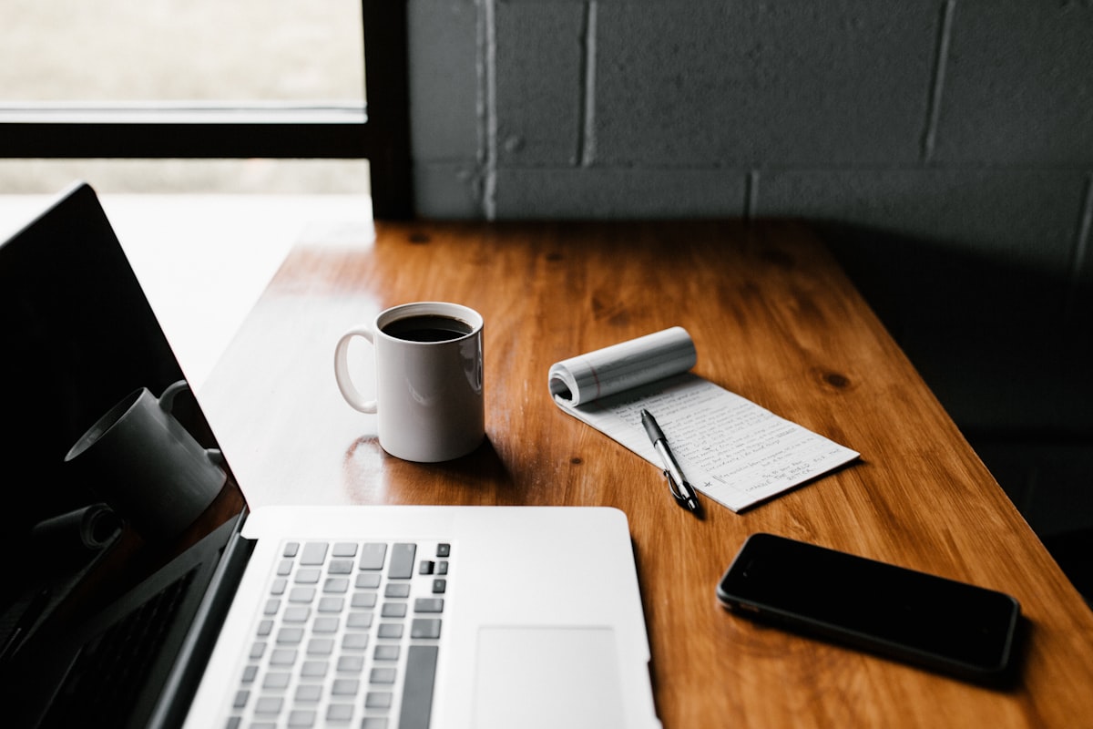 A writing desk with a laptop and notebook, representing content planning work