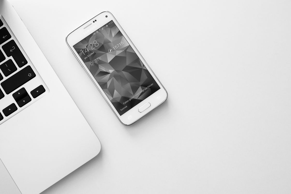 Laptop and smartphone arranged on a clean desk workspace
