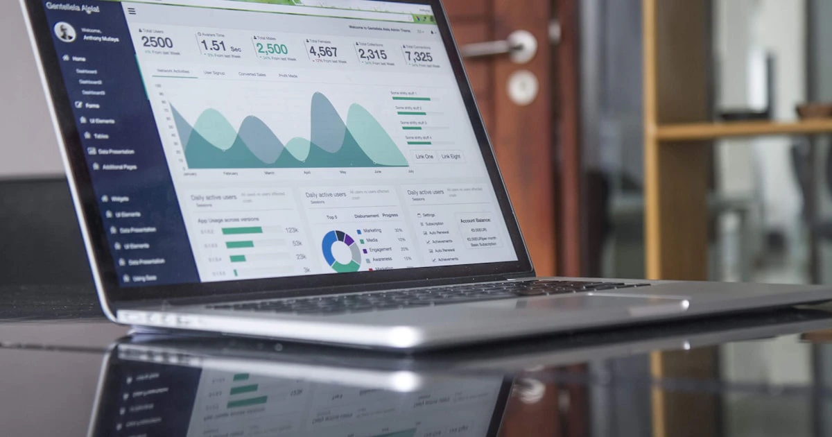 Marketing team analyzing data and metrics on laptop screens in a modern office workspace
