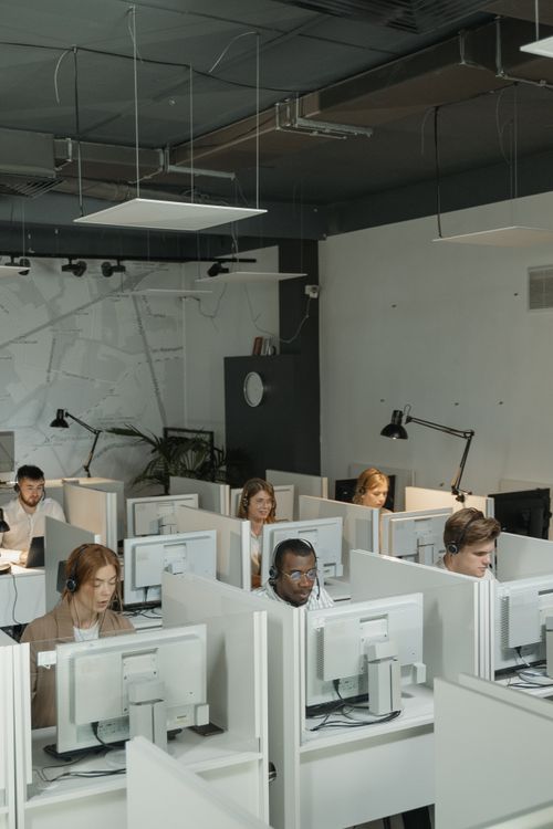 Customer service team working at computers in a busy support office