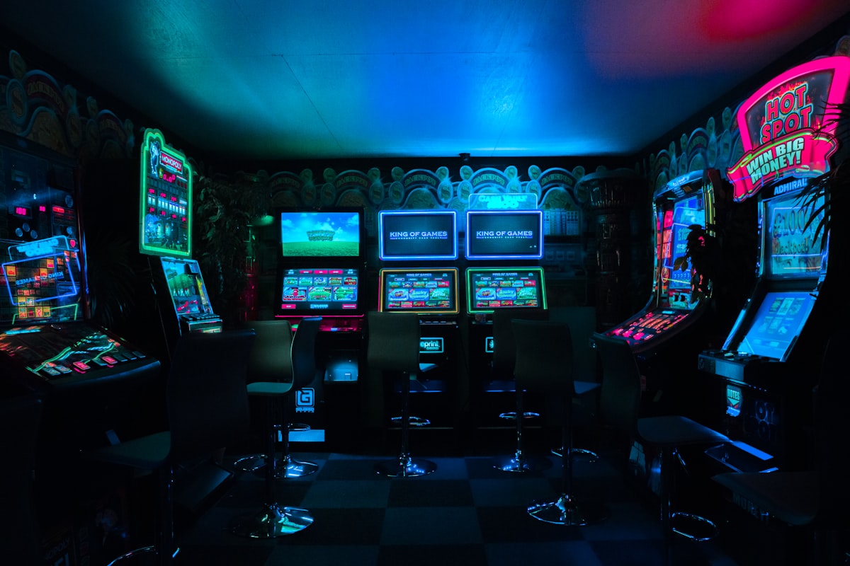 Close-up view of a colorful pinball machine playfield illuminated by arcade lights
