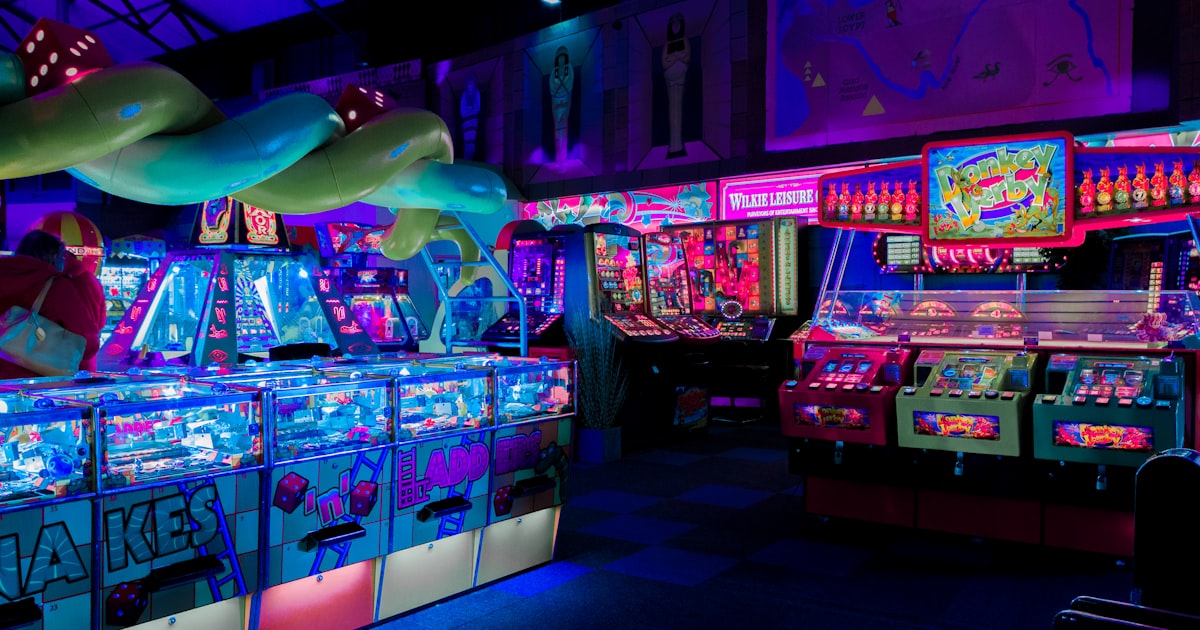 Neon-lit arcade venue with pinball and arcade machines in an evening commercial setting
