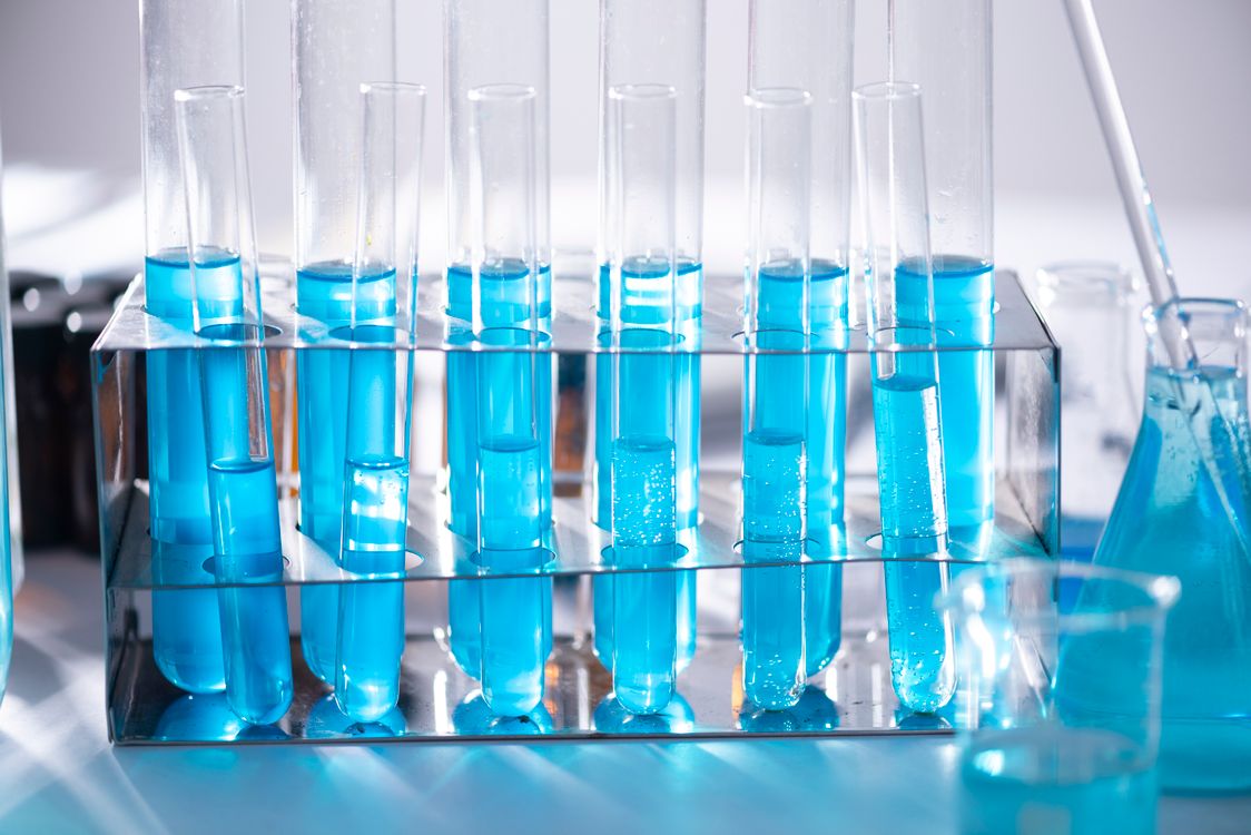 Blue liquid in laboratory test tubes demonstrating pharmaceutical quality control testing.