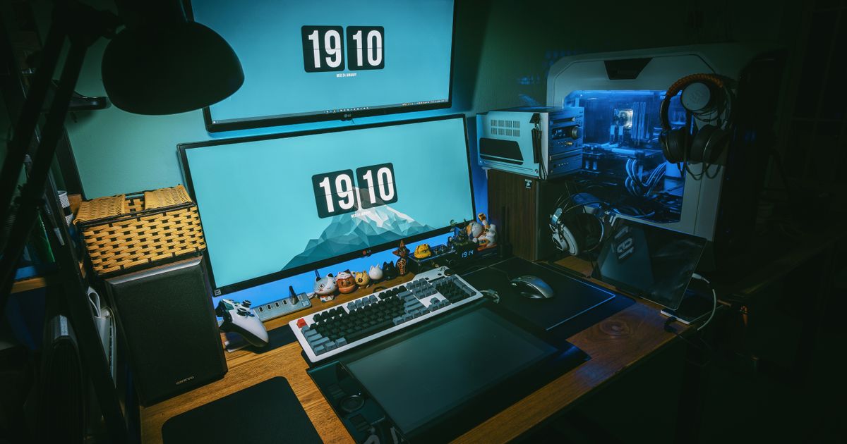 A low-light PC gaming setup with dual monitors and RGB lighting