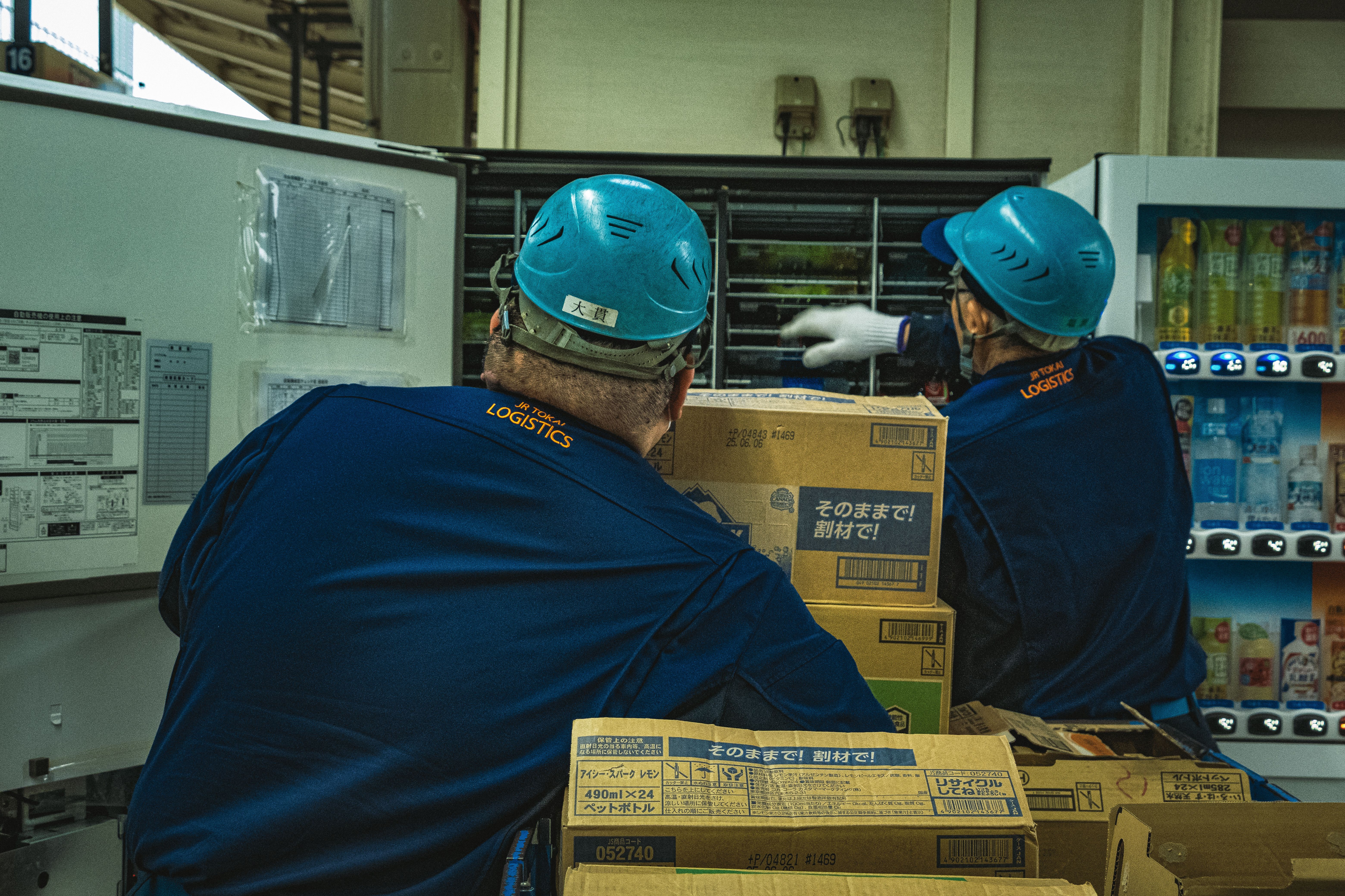 Warehouse workers organizing logistics boxes near storage equipment