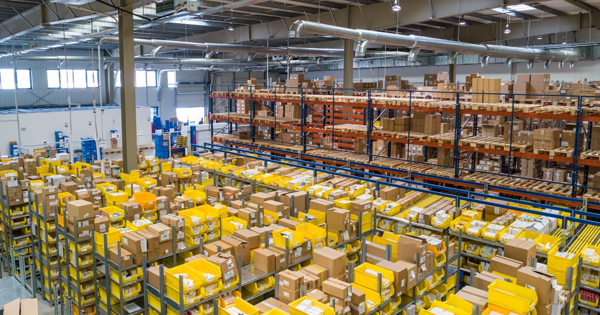 Industrial warehouse aisle with stacked cardboard boxes on metal shelving