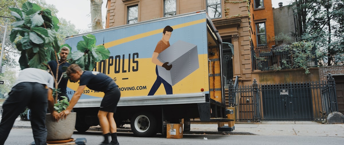 Professional movers carrying cardboard boxes during a residential move