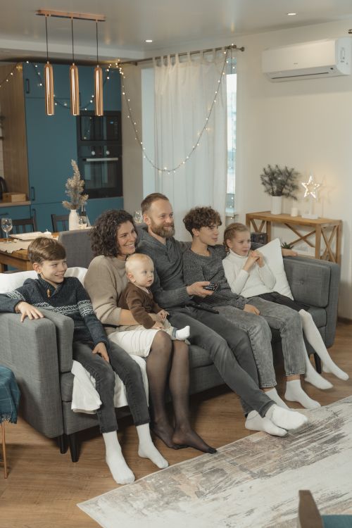 Family sitting together on a sofa watching television at home