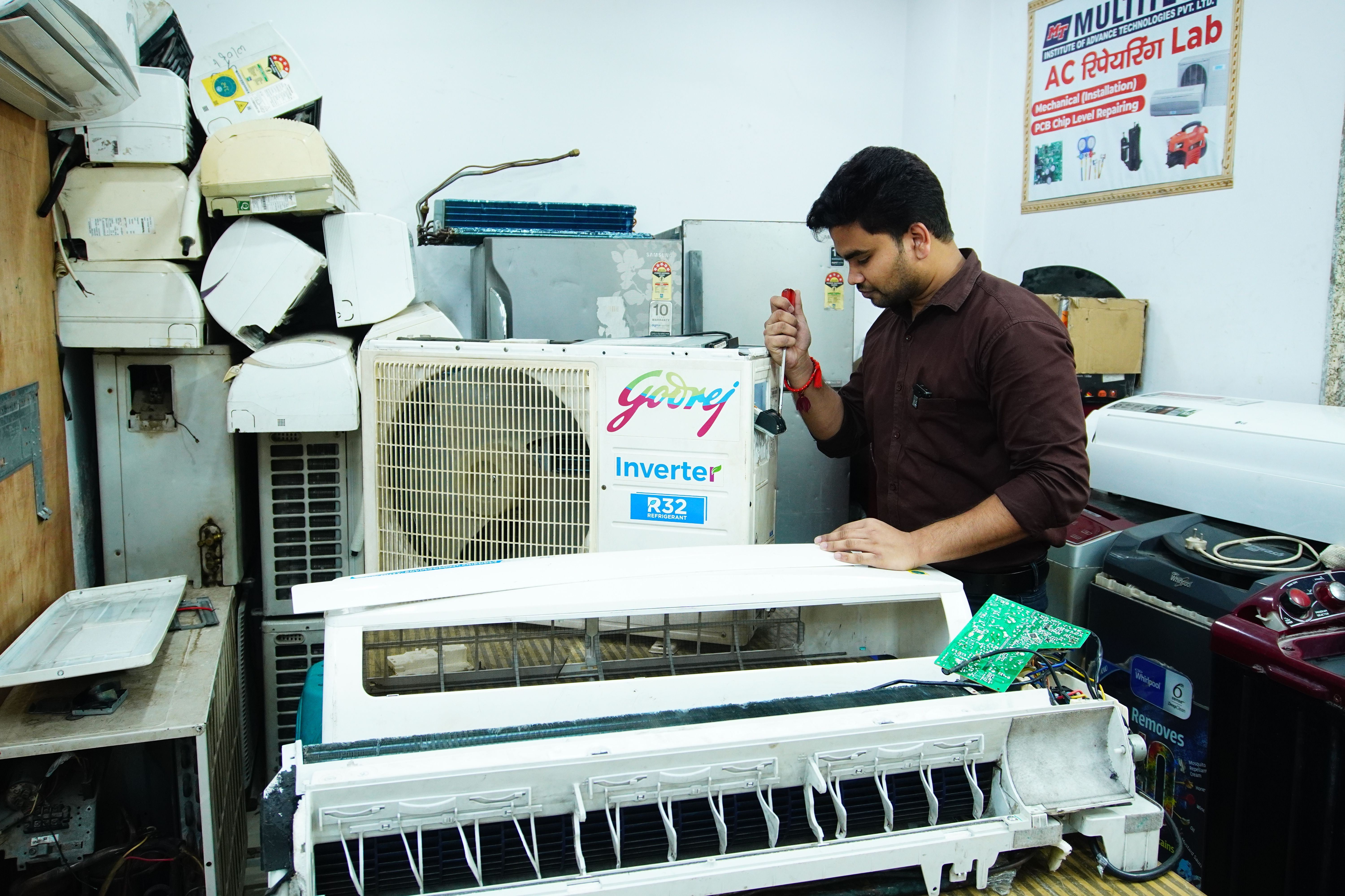 HVAC technician repairing a split air conditioner unit with diagnostic tools