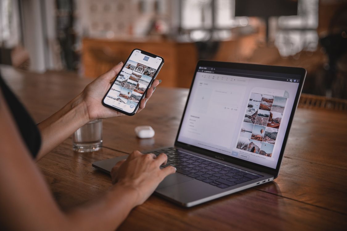 Marketer reviewing social media comments on a laptop and phone