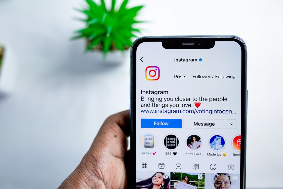 Hand holding a smartphone with the Instagram app open
