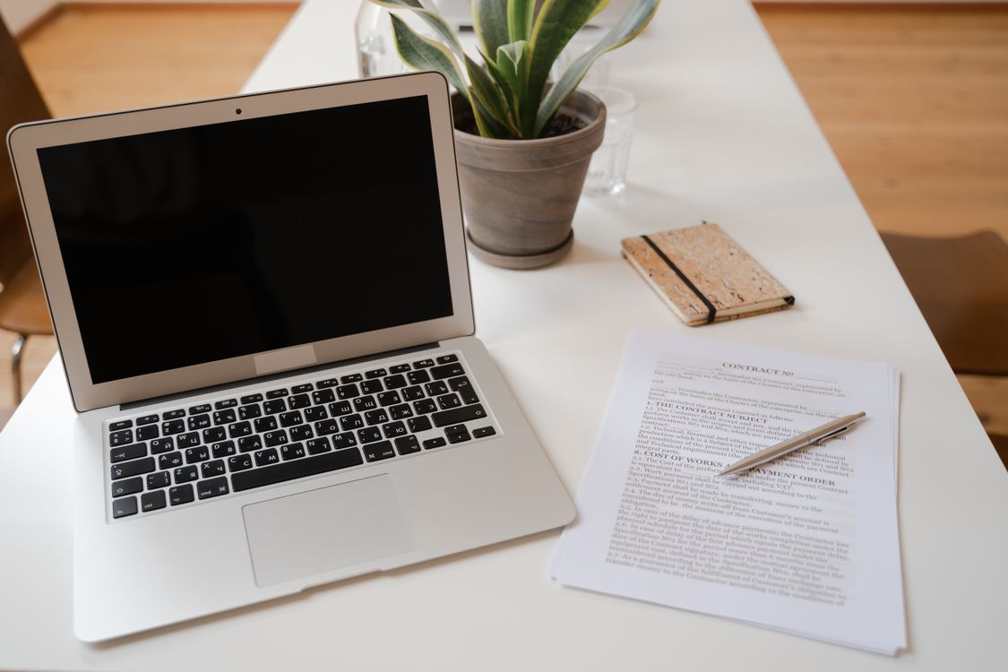 Professional workspace with laptop and business documents on a clean desk
