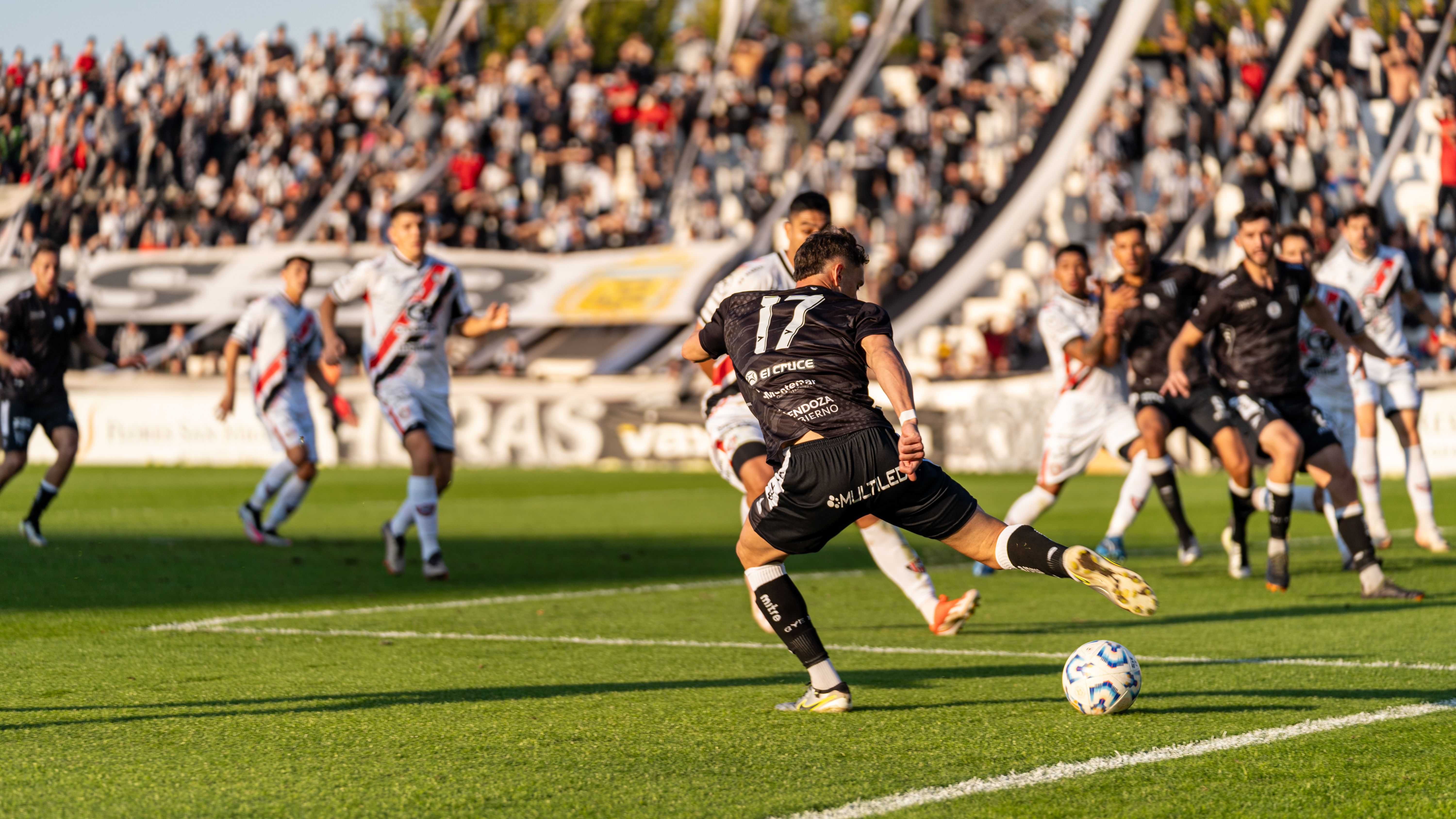 Professional football match in a packed stadium with players competing