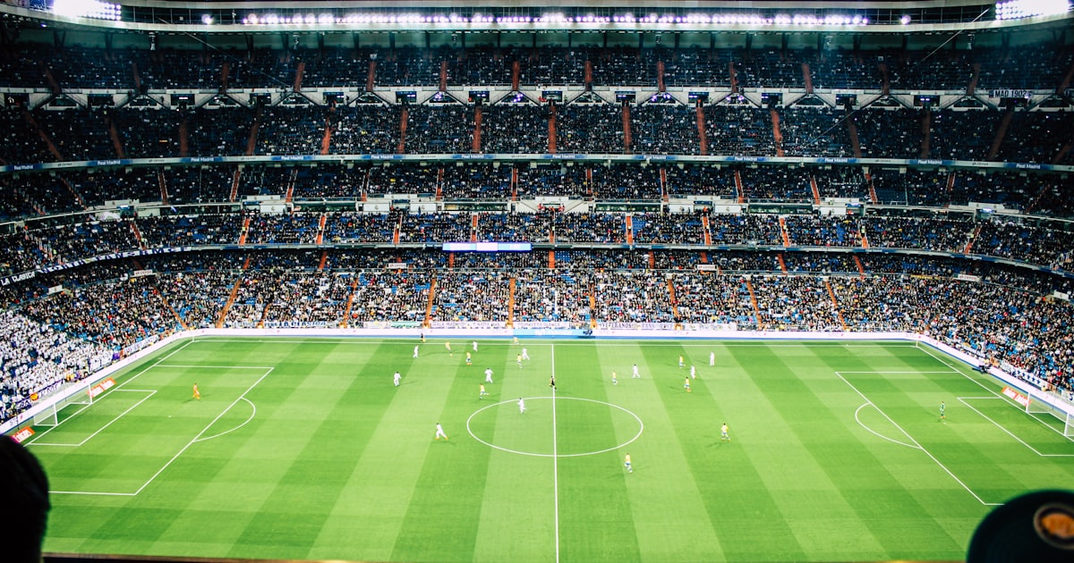 Packed football stadium under floodlights during an evening match