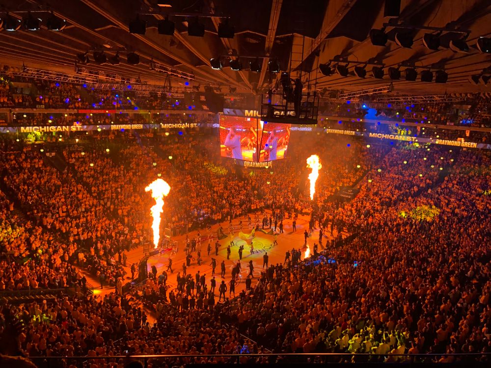 Packed basketball arena with cheering fans during a live game