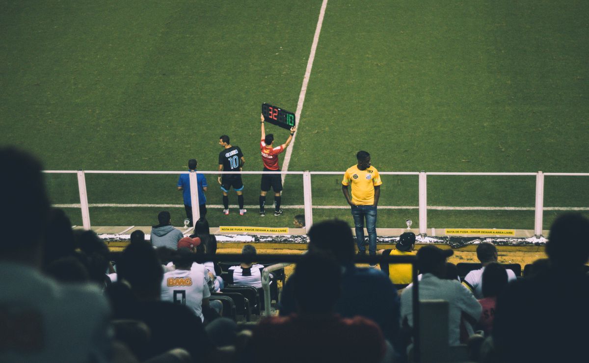 Crowd of fans cheering in a soccer stadium during a live match
