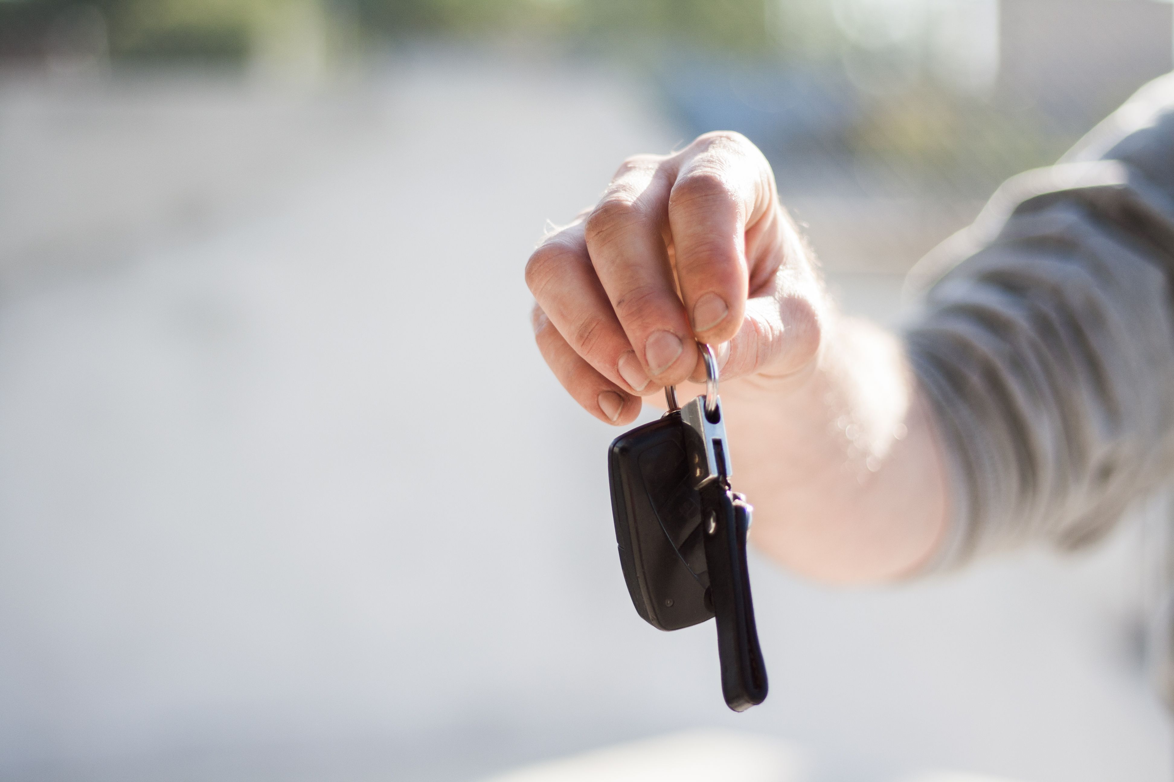 Chauffeur in a suit standing beside a luxury car, ready to greet a client