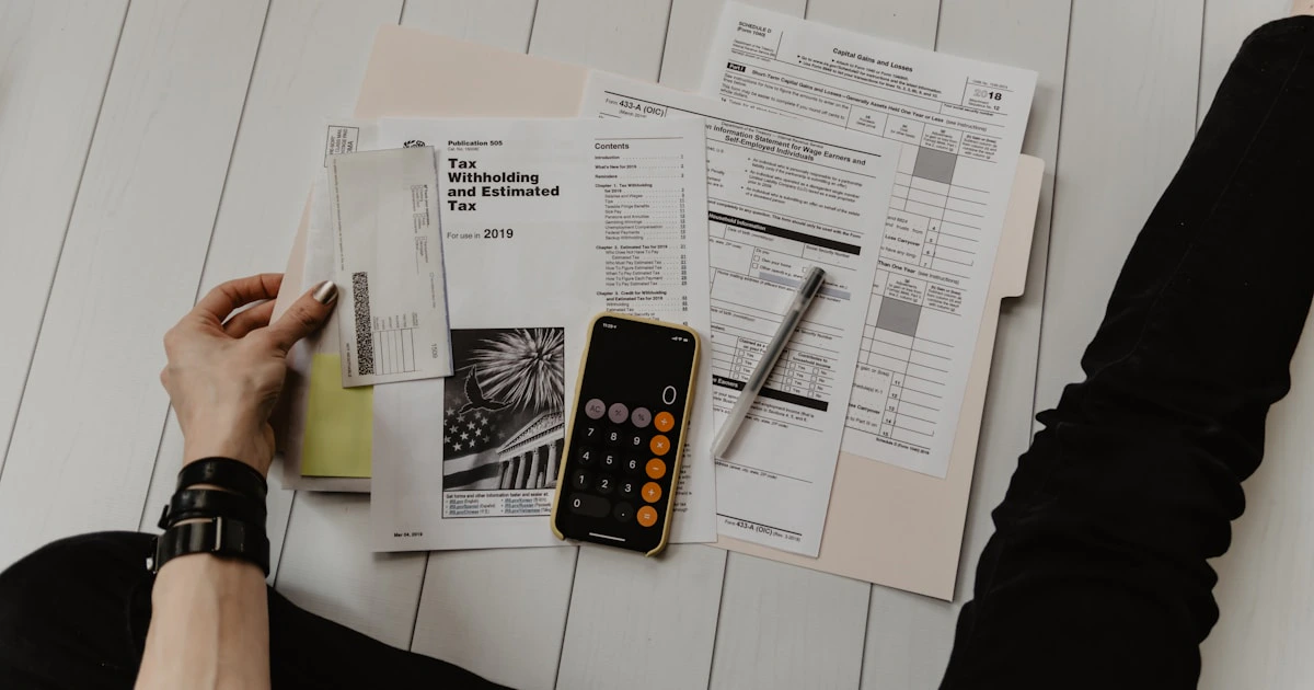 Calculator and financial documents on a desk showing business cost savings