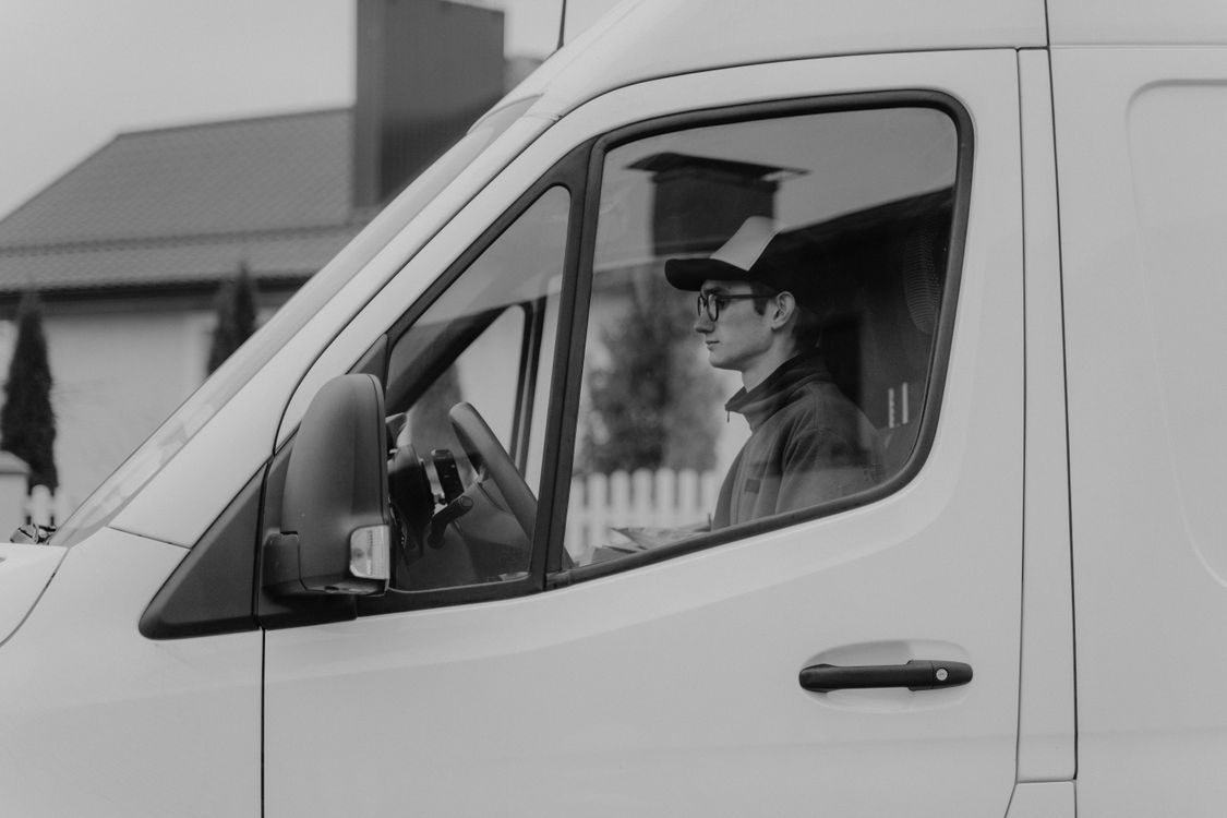 Driver at the wheel of a shuttle van representing dispatch operations