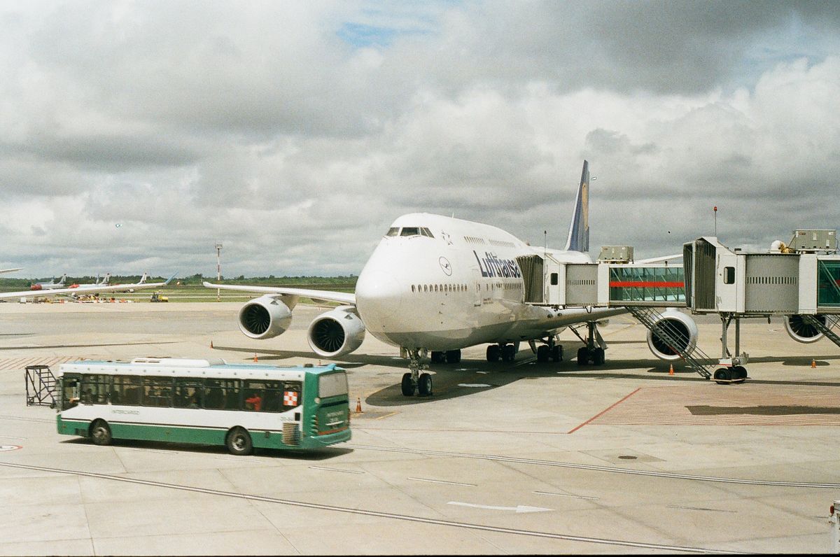 Airport shuttle van near a terminal, the kind of operation moving off manual scheduling