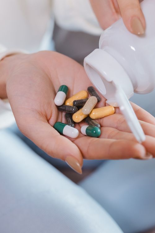 Dietary supplement capsules held in a woman's hands
