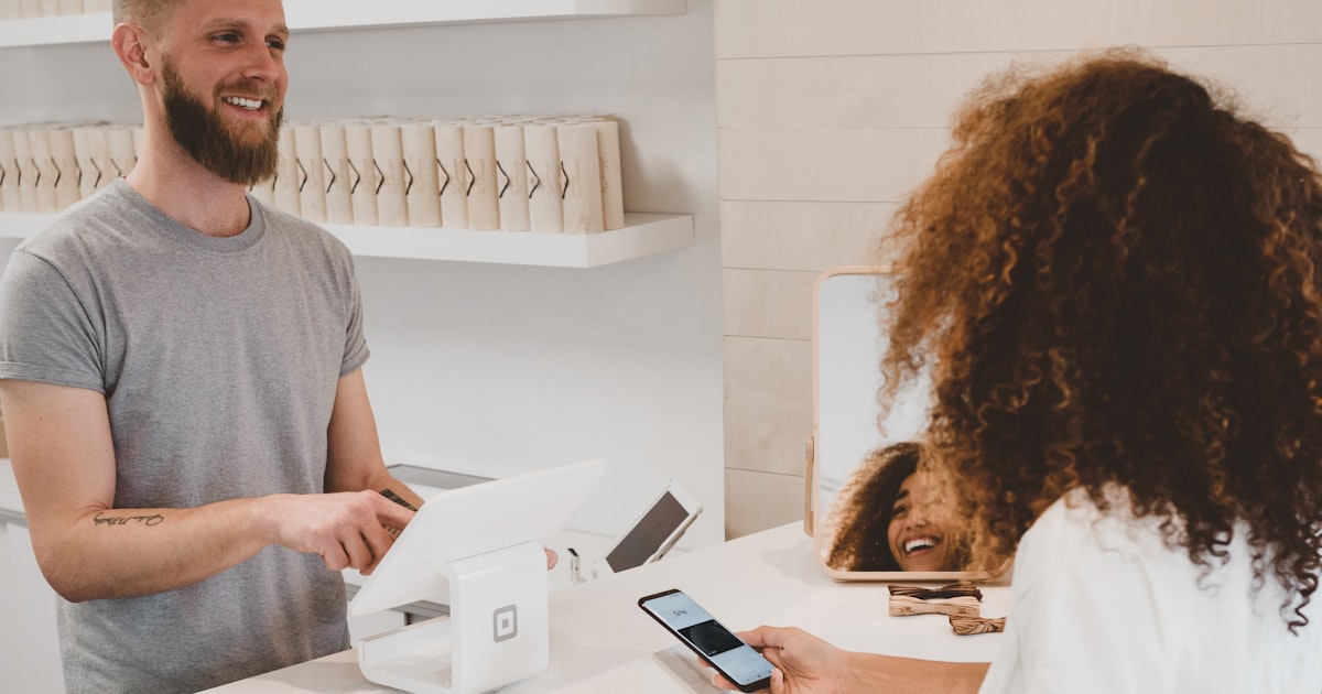Person using a smartphone to shop online with a credit card in hand