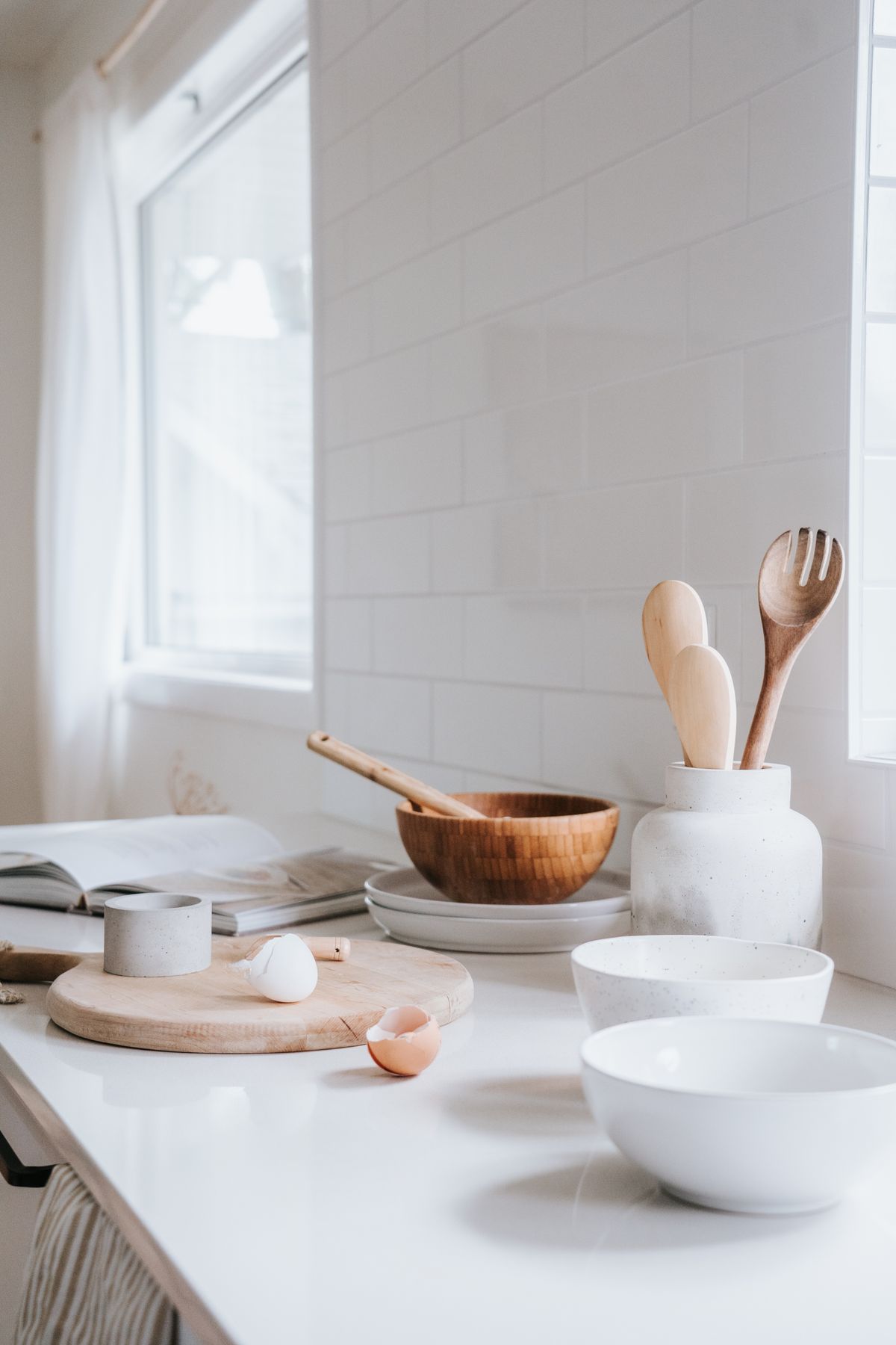 White ceramic plates and bowls arranged on a kitchen counter