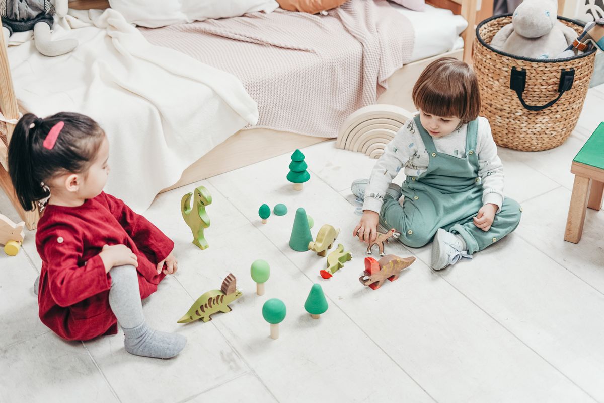 Two children playing together with wooden educational toys