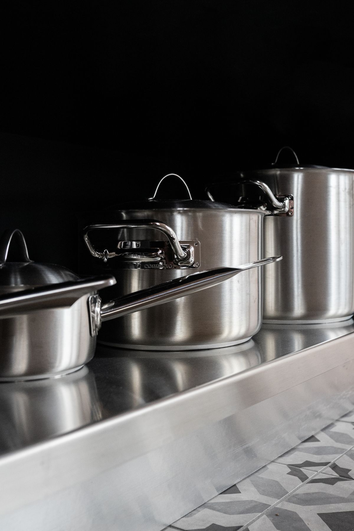 Stainless steel cooking pots on a modern kitchen counter
