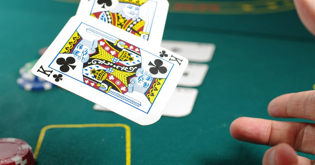 Overhead view of playing cards and poker chips scattered on a dark casino table