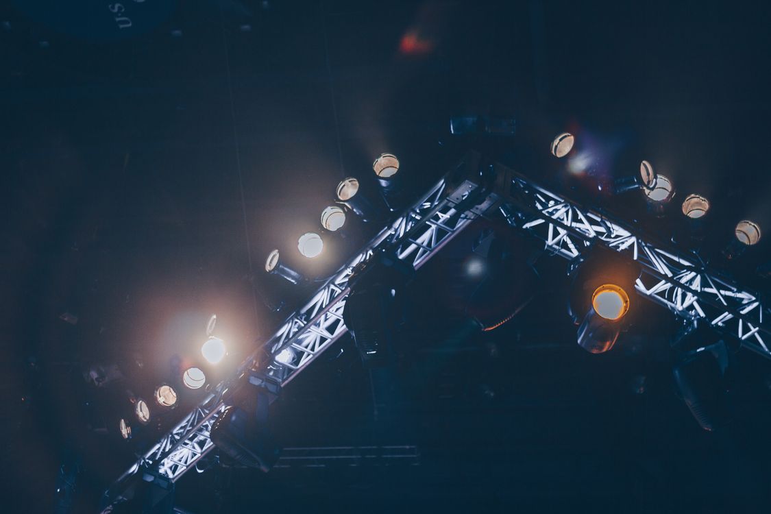 Professional stage lighting illuminating a venue with dramatic beams of colored light