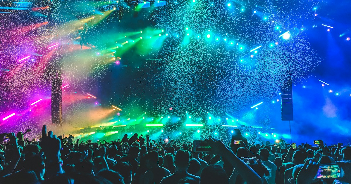 Concert venue lit with colorful stage lights and atmospheric effects