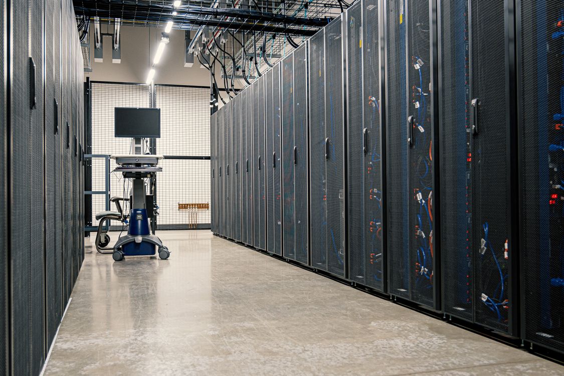 Server racks in a modern data center with blue LED lighting and cable management systems.