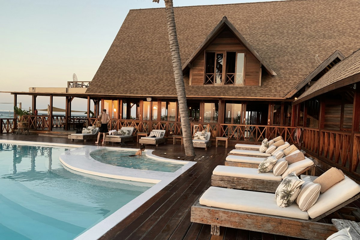 Luxury tropical resort pool surrounded by palm trees at dusk