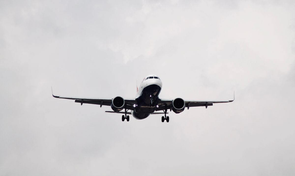 Commercial airplane soaring through a clear blue sky