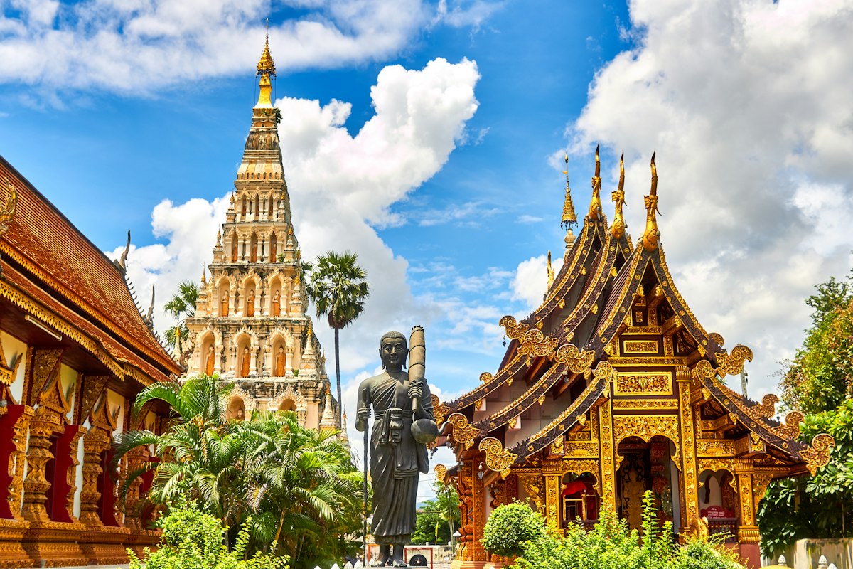Golden spires of Wat Phra Kaew temple in Bangkok, Thailand against a blue sky