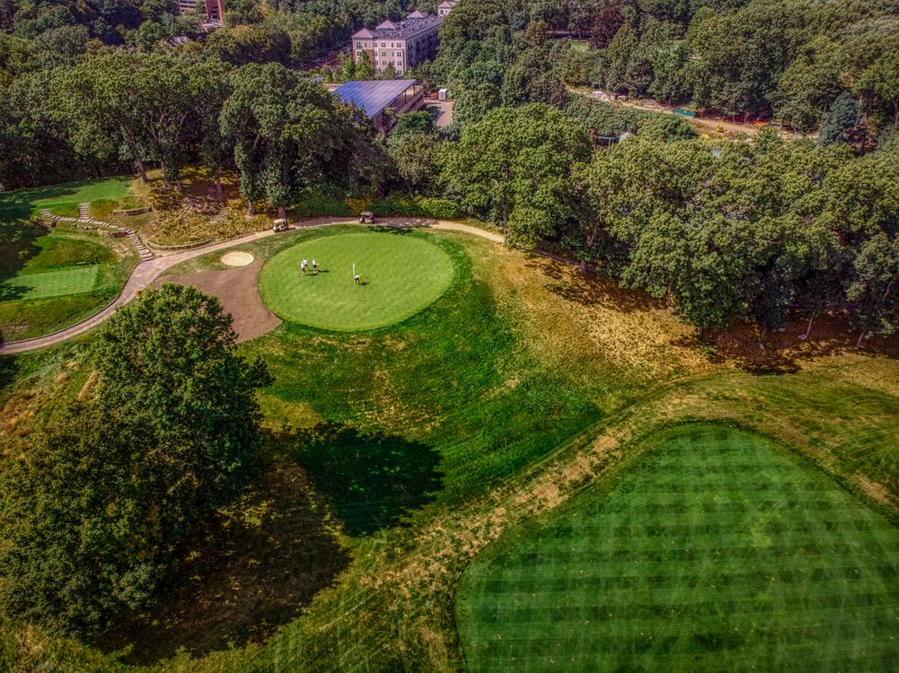 Aerial view of golfers on a lush green fairway showing the full course layout