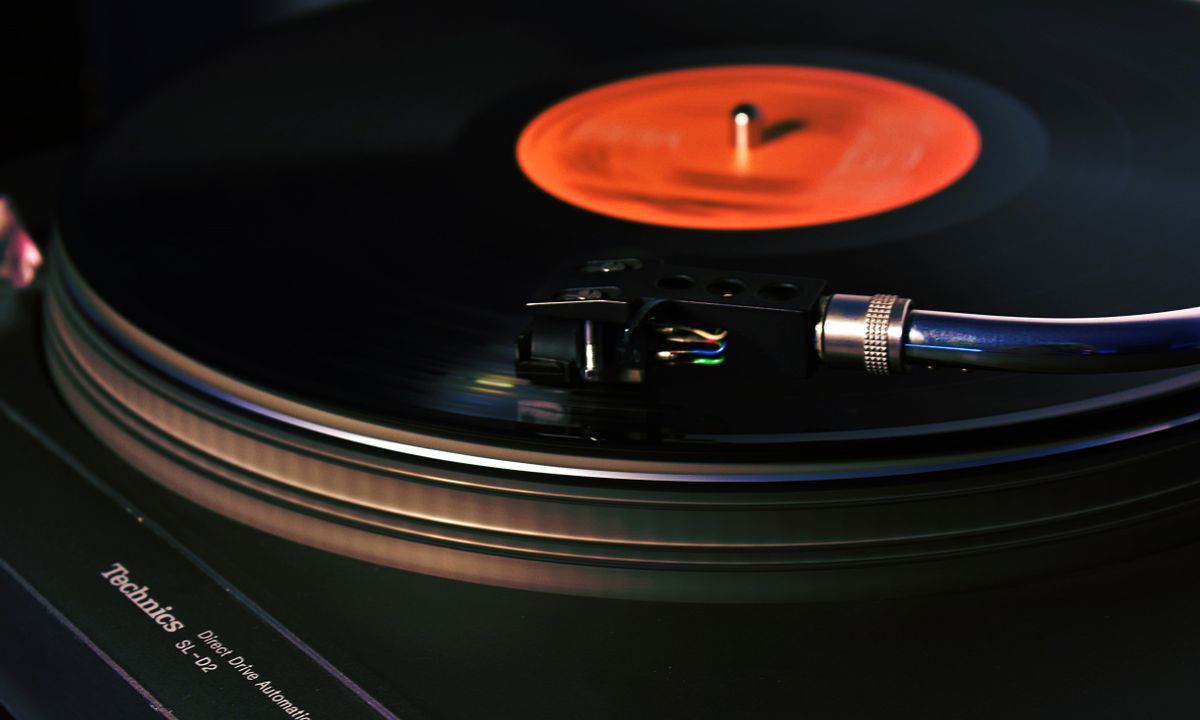 Tornamesa negra reproduciendo un disco de vinilo en un sistema Hi-Fi
