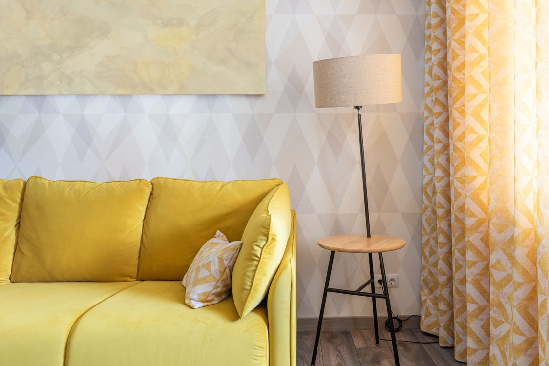 Modern living room interior with a minimalist sofa and contemporary floor lamp in neutral tones