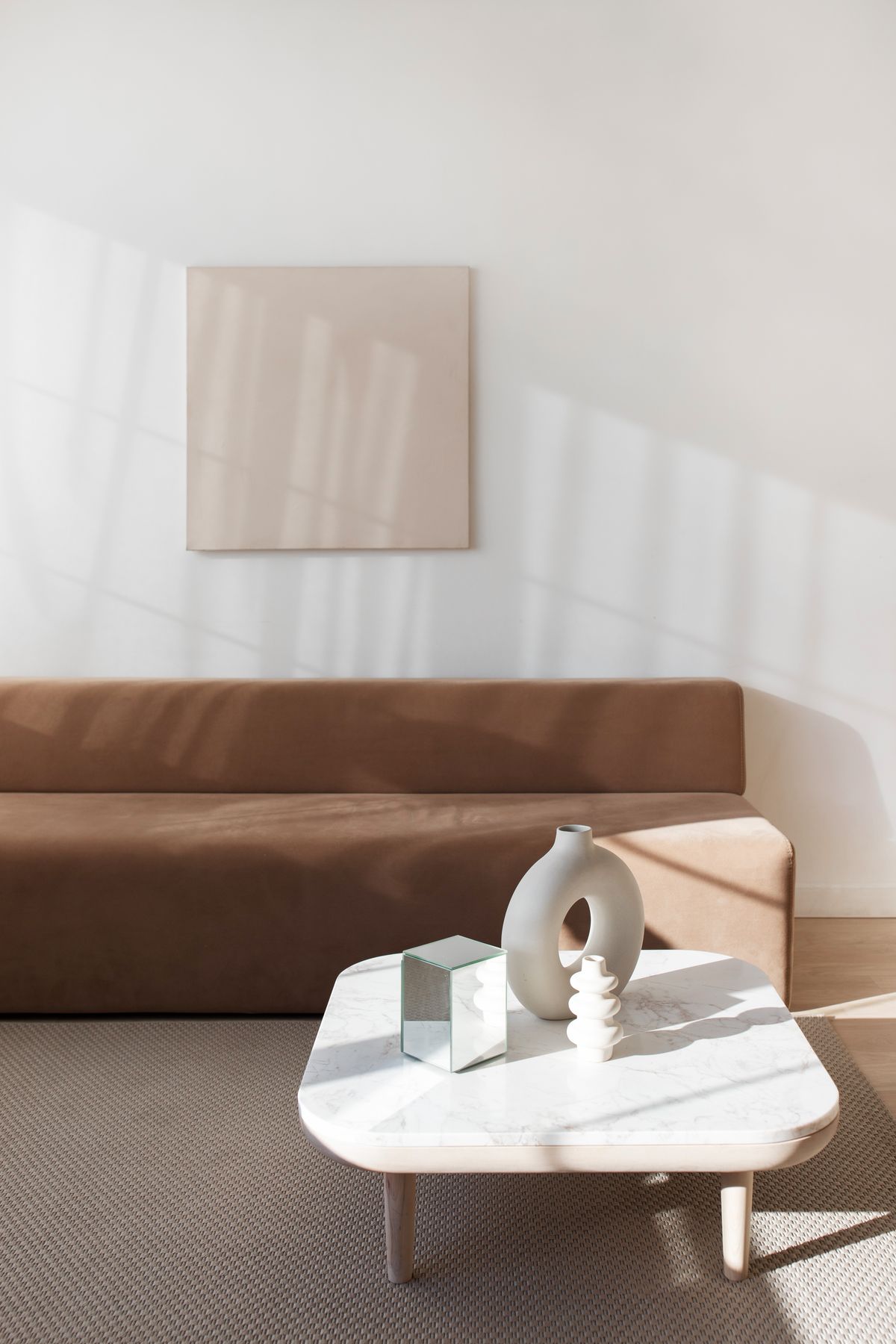 Styled minimalist living room with a brown sofa in bright natural light