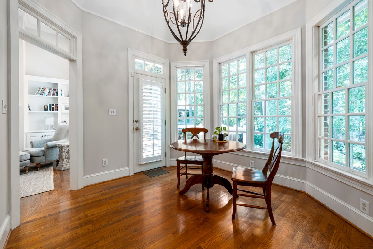 Clean wooden dining table and matching chairs in a bright, airy room