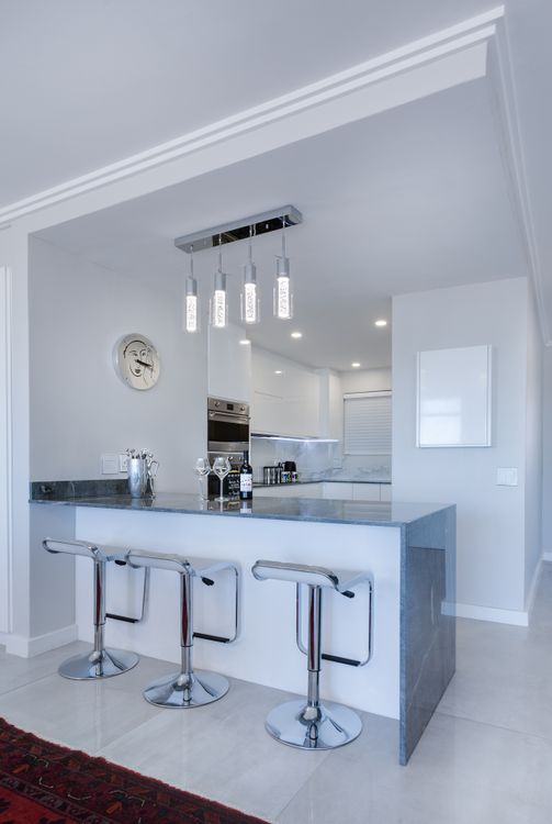 White minimalist bar counter with modern stools in a stylish kitchen setting