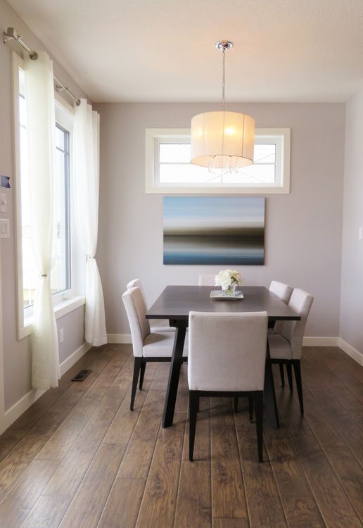 Minimalist wooden dining table with a pendant lamp in a bright contemporary space