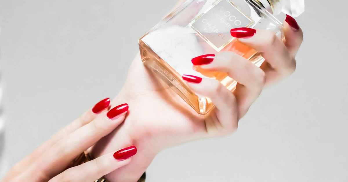 Flacon de parfum doré et noir posé sur une surface élégante, représentant l'art de la parfumerie de luxe orientale