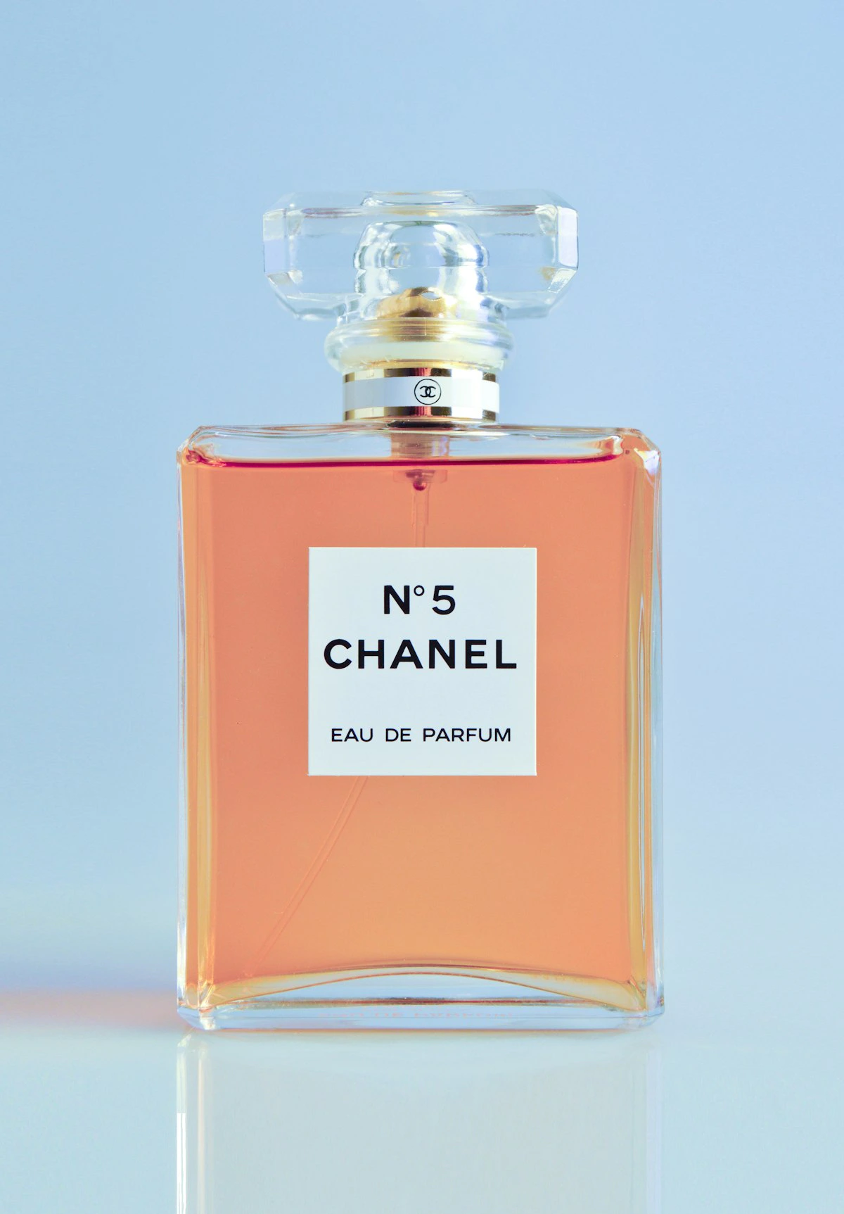 Flacons de parfum élégants disposés sur une surface réfléchissante