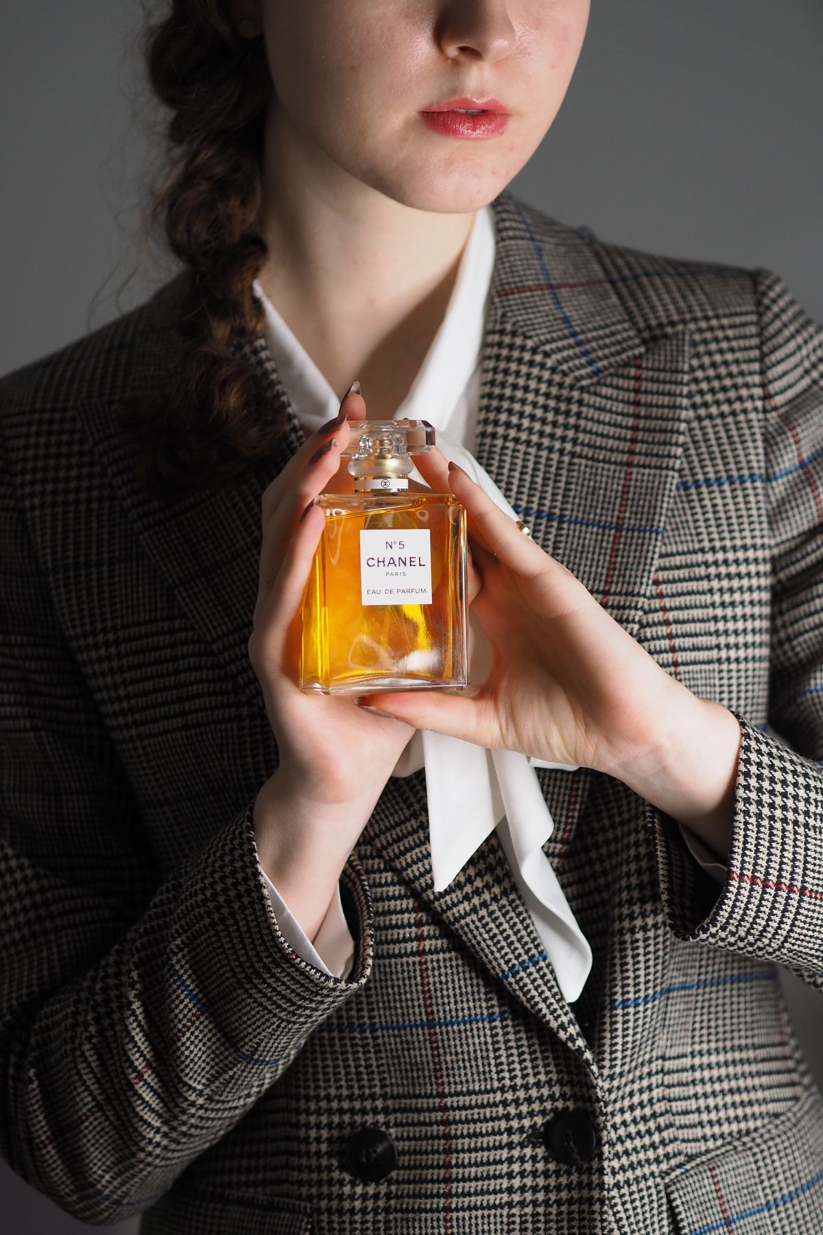 Jeune femme élégante tenant un flacon de parfum de luxe