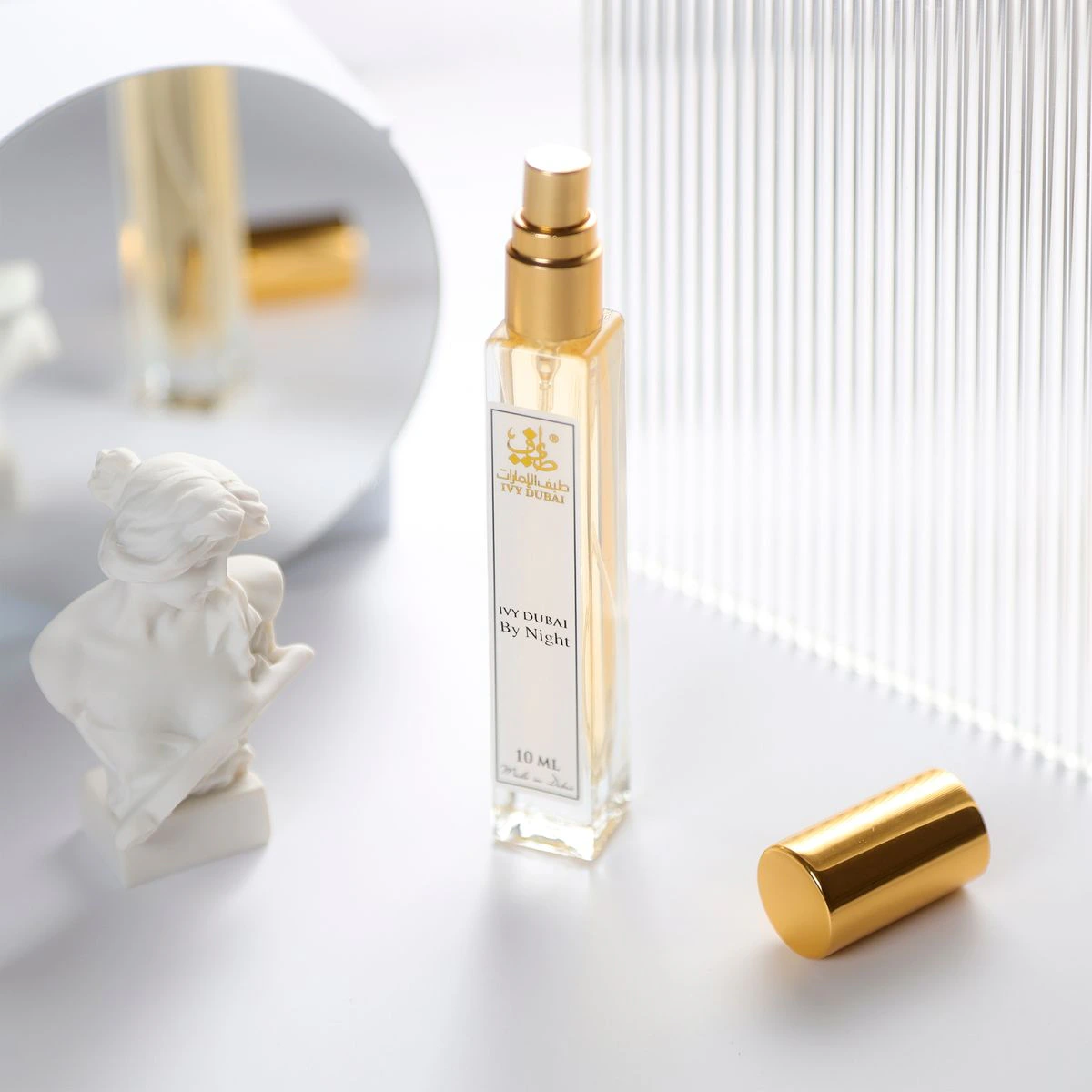 Flacon de parfum doré sur fond clair pour tester une fragrance