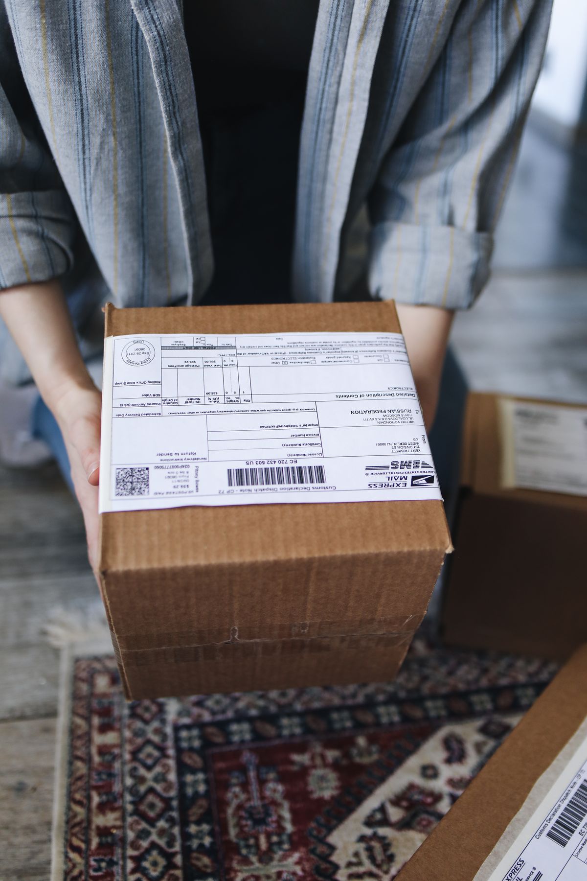Livreur tenant un colis carton prêt à être remis au client