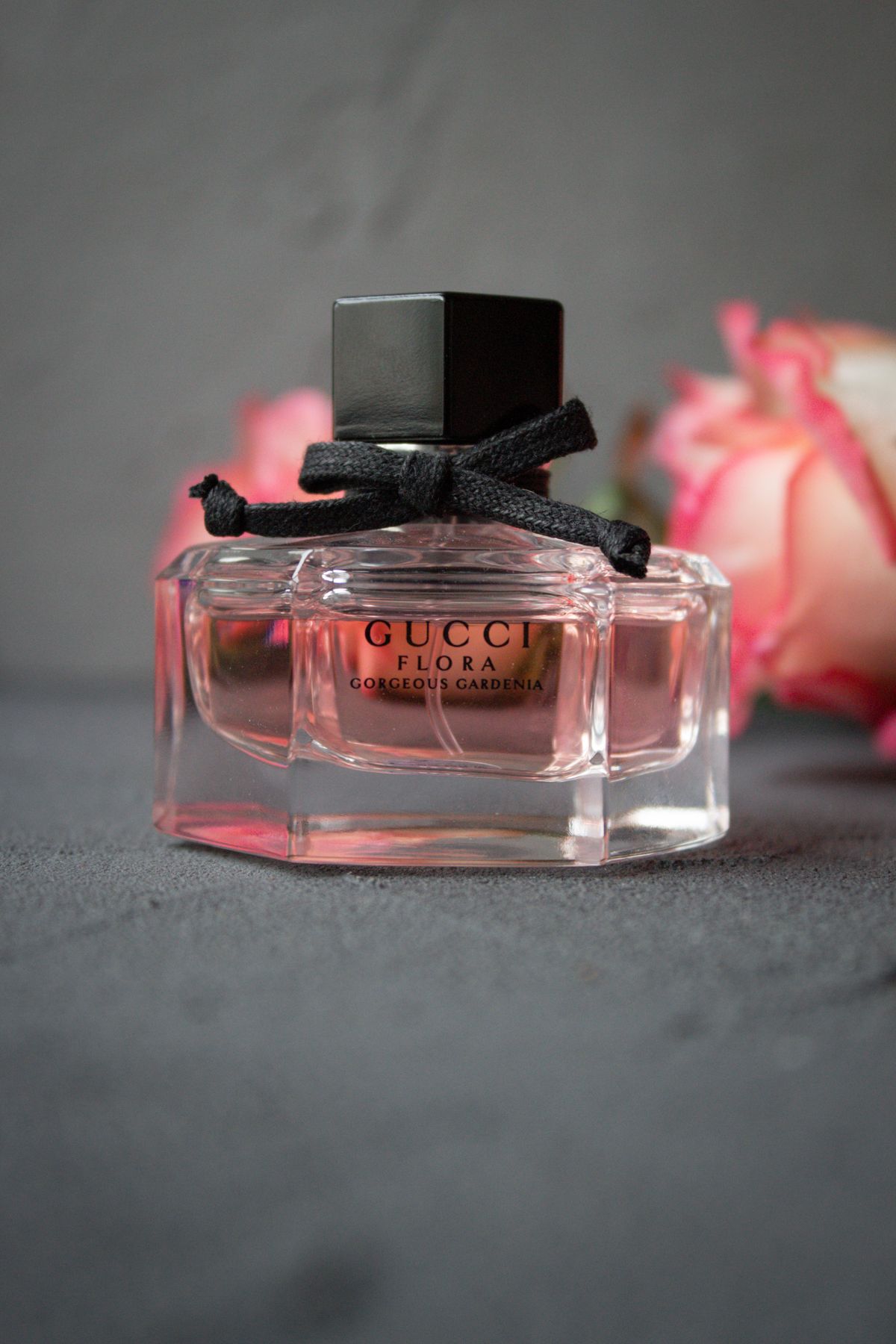 Flacon de parfum élégant entouré de roses roses sur fond doux